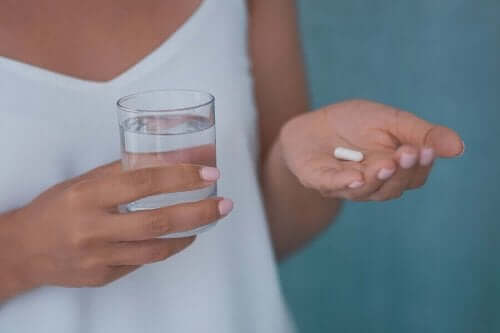 Γυναίκα κρατά ένα χάπι και ένα ποτήρι νερό ολανζαπίνη