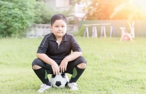 Παιδί κάθεται πάνω σε μπάλα ποδοσφαίρου