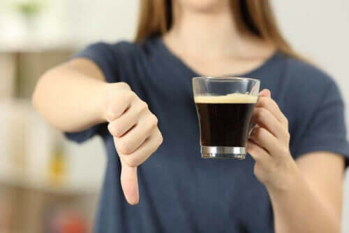 Γυναίκα κρατά ποτήρι με καφέ και λέει όχι