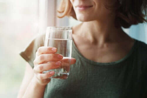 Γυναίκα κρατά ποτήρι με νερό