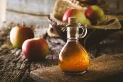 Μηλόξυδο σε γυάλινο μπουκάλι και μήλα