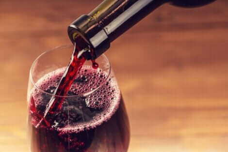 Άτομο βάζει κόκκινο κρασί σε ποτήρι