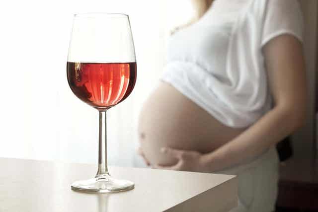 Έγκυος γυναίκα και ποτήρι με κρασί