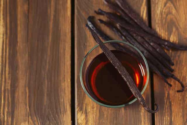 Εκχύλισμα βανίλιας σε ποτήρι και λοβοί