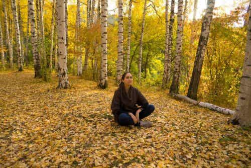 Γυναίκα κάθεται στο έδαφος σε δάσος
