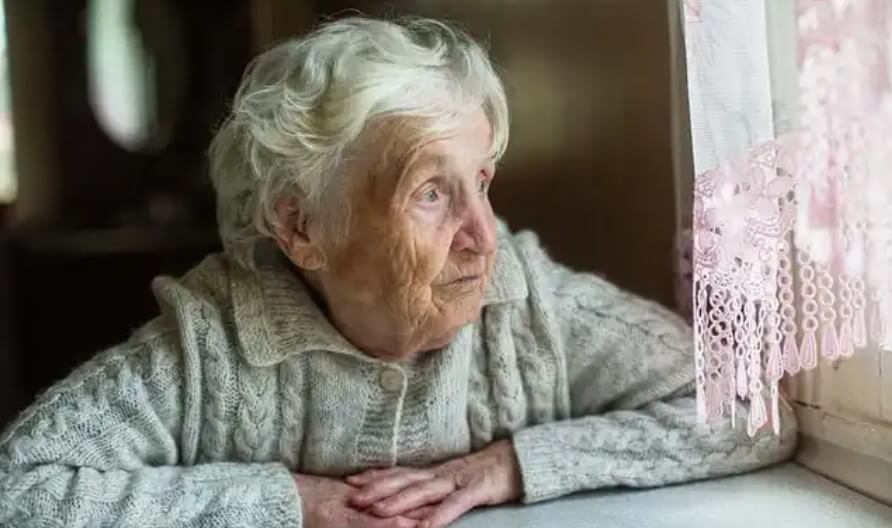 ηλικιωμένη γυναικα σε παράθυρο