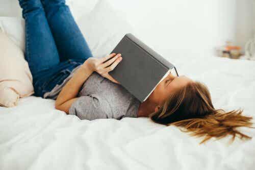 Γυναίκα διαβάζει ξαπλωμένη σε κρεβάτι