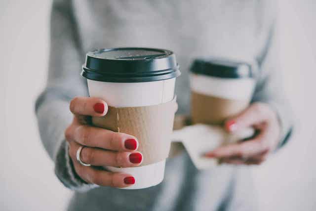 Γυναίκα κρατά δύο ποτήρια με καφέ