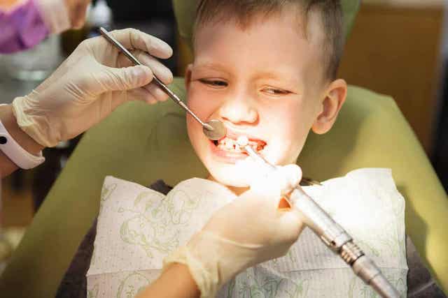 Οδοντίατρος ελέγχει τα δόντια παιδιού