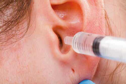 Άτομο βάζει σταγόνες στο αυτί με σύριγγα