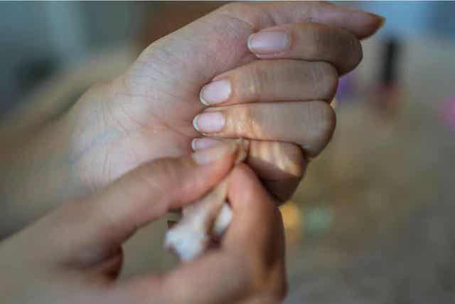 Γυναίκα αφαιρεί το βερνίκι νυχιών